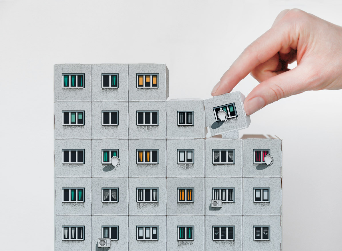 Image from Panelki showing a hand assembling a Soviet apartment block facade out of modular pieces