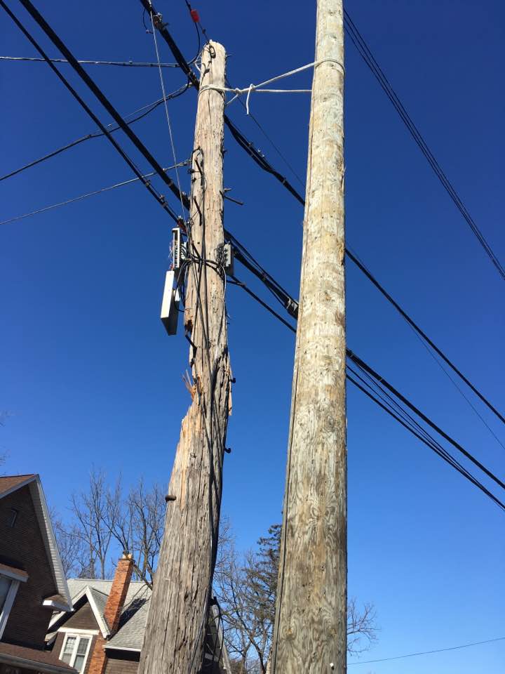 Photo of a N Main St utility pole, having been severed by a crash with a large truck, fixed for months with a rope lashing