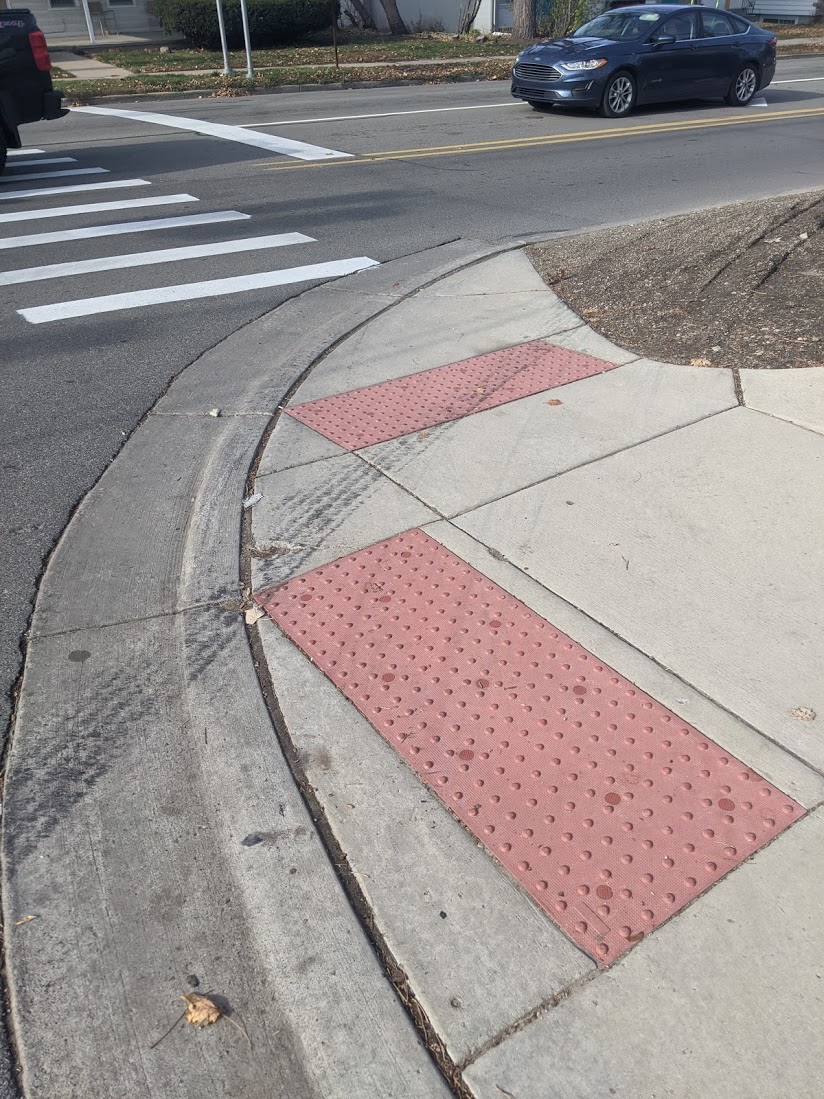 photo of tire tracks on the sidewalk at an intersection